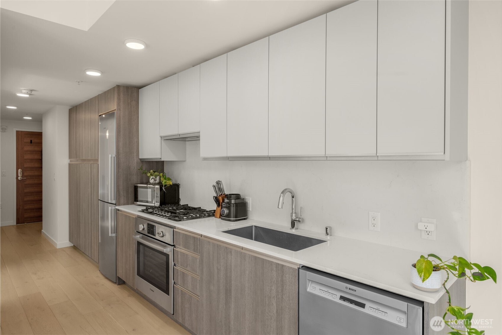 800 Columbia Street, Unit 808 Seattle, WA 98104 - Photo 33 of 38 a kitchen with stainless steel appliances granite countertop a sink a stove and a refrigerator