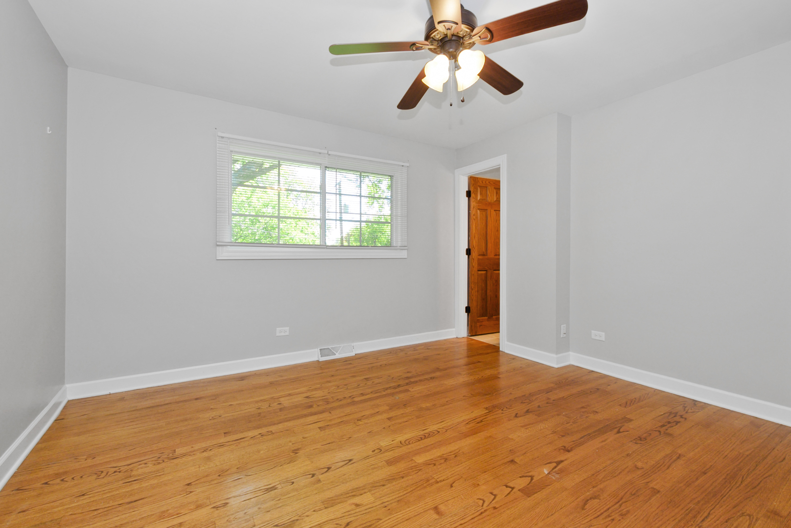 433 Hackberry Road Frankfort, IL 60423 - Photo 12 of 27 an empty room with wooden floor chandelier fan and windows