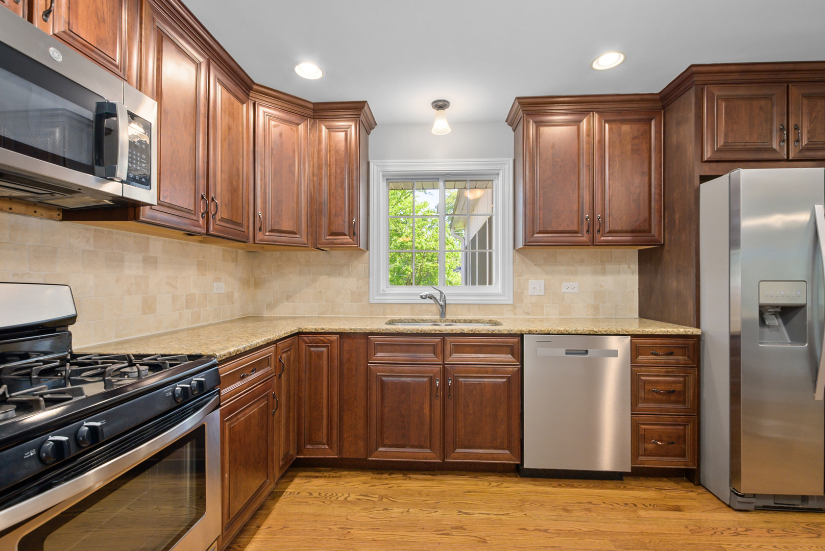 433 Hackberry Road Frankfort, IL 60423 - Photo 3 of 27 a kitchen with stainless steel appliances granite countertop a stove top oven a sink dishwasher a refrigerator and cabinets with wooden floor