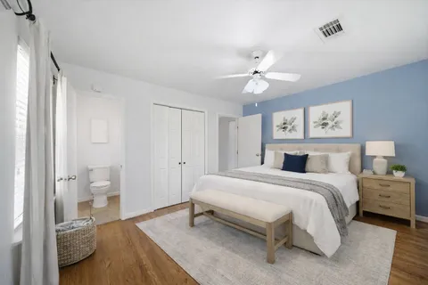 a spacious bedroom with a bed and a chandelier