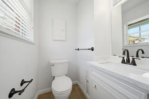a bathroom with a toilet a sink and mirror