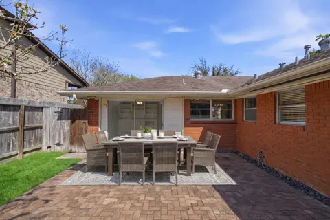 a view of a house with backyard sitting area and garden
