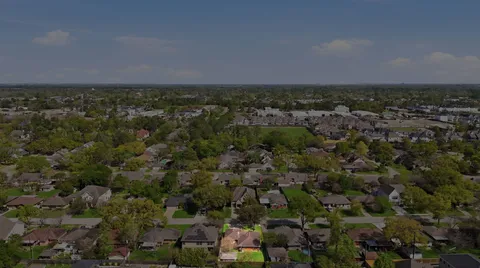 an aerial view of a houses with city and green space