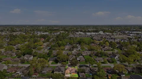 an aerial view of a houses with city and green space