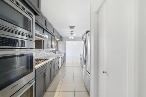a kitchen with stainless steel appliances granite countertop a refrigerator and a stove