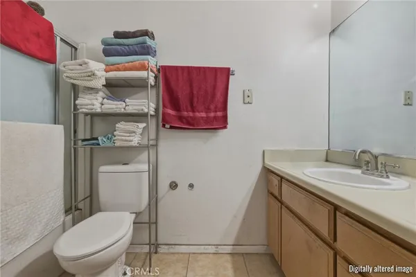 a bathroom with a granite countertop toilet sink and mirror