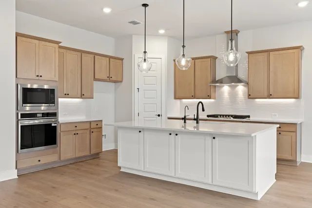 a kitchen with stainless steel appliances granite countertop a stove a sink and a refrigerator