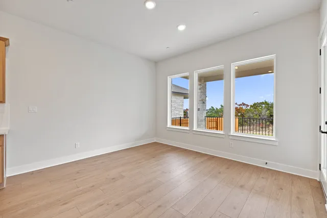 a view of a kitchen with kitchen island stainless steel appliances wooden floor and living room view