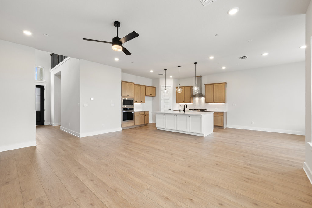 6313 Leftwich Cove Austin, TX 78738 - Photo 12 of 39 a view of a kitchen with kitchen island stainless steel appliances wooden floor and living room view