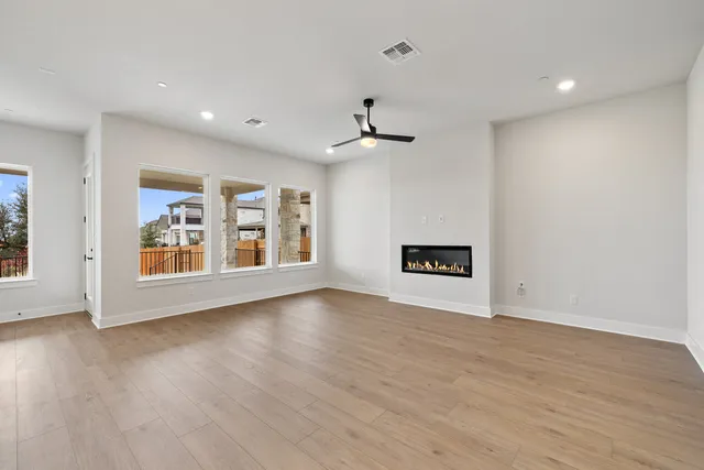 a large kitchen with stainless steel appliances granite countertop a stove a sink a refrigerator and a island with wooden floor