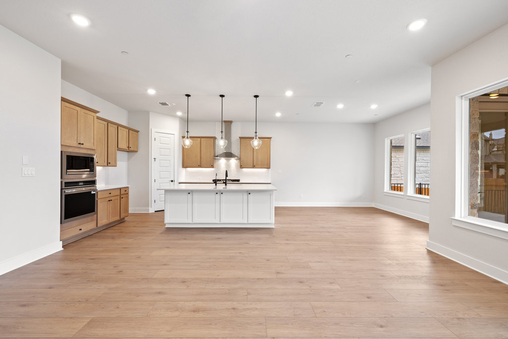 6313 Leftwich Cove Austin, TX 78738 - Photo 39 of 39 a large kitchen with stainless steel appliances kitchen island a large counter top and a wooden floors