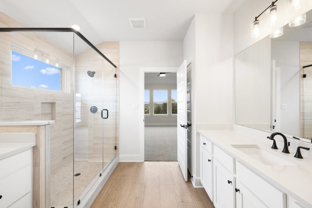 6313 Leftwich Cove Austin, TX 78738 - Photo 4 of 39 a bathroom with a shower sink and mirror