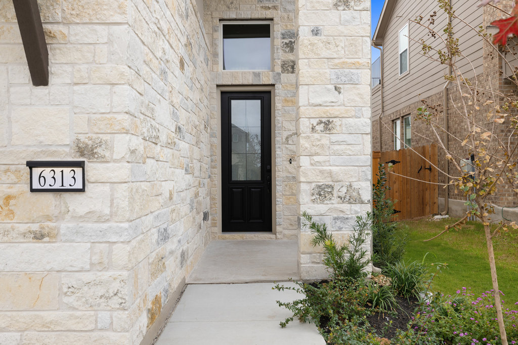 6313 Leftwich Cove Austin, TX 78738 - Photo 7 of 39 a brick building with a door and a yard