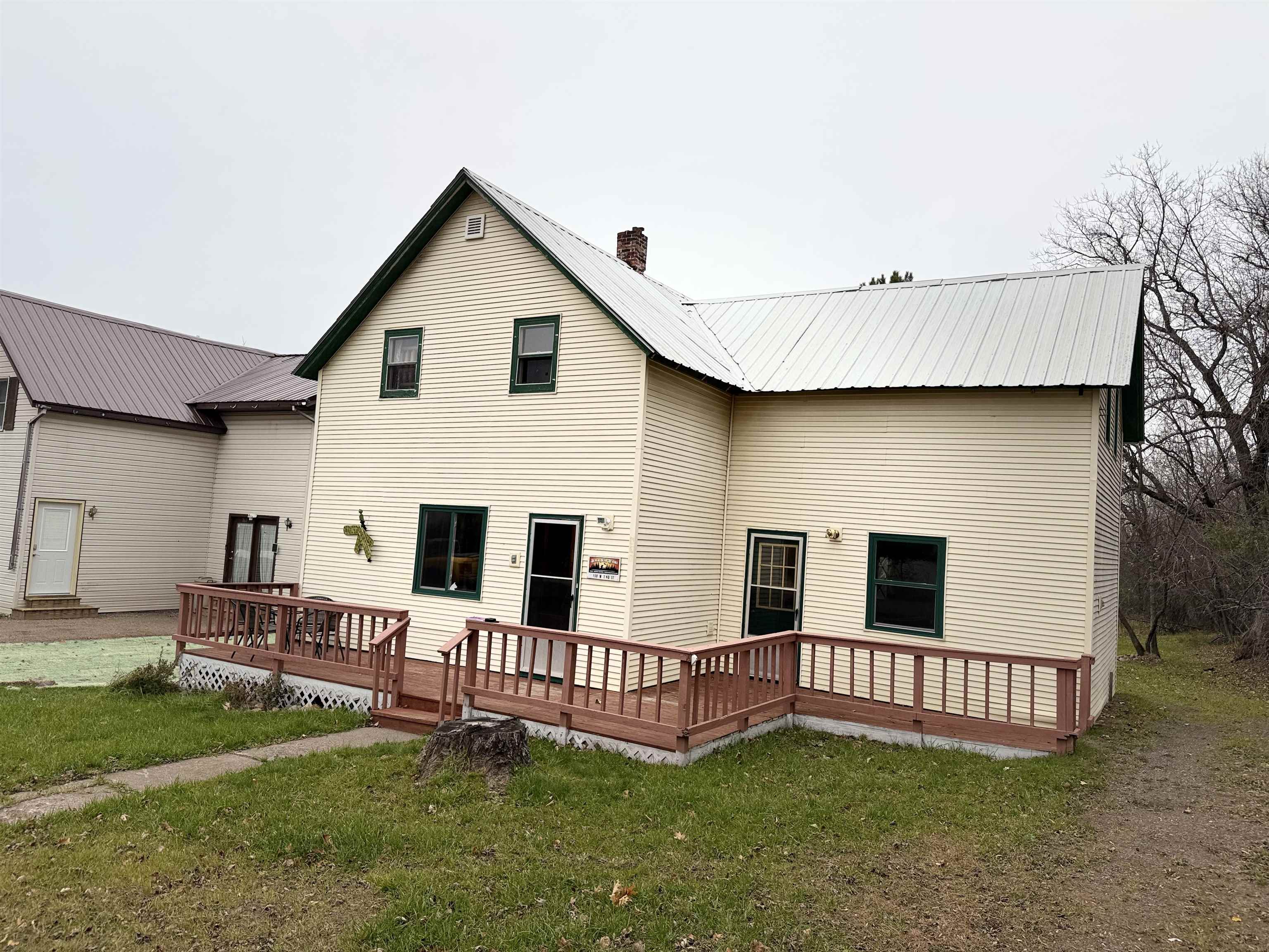 150 West 2nd Street Glidden, WI 54527 - Photo 3 of 32 Rear view of house with a deck, a lawn, and a metal roof