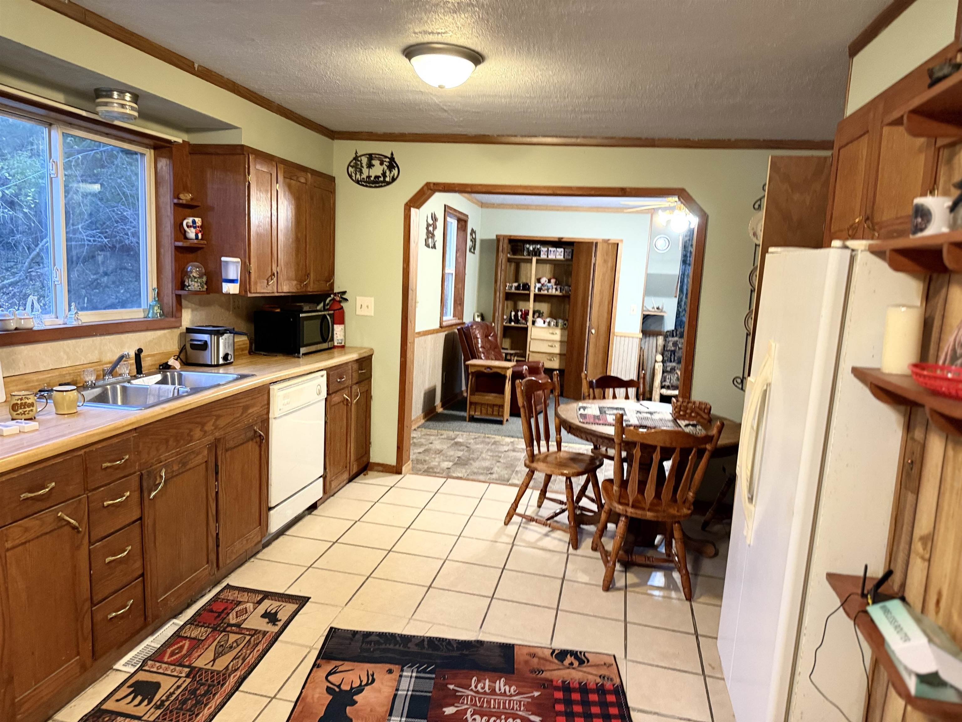 150 West 2nd Street Glidden, WI 54527 - Photo 7 of 32 Kitchen featuring crown molding, a textured ceiling, white appliances, light countertops, and arched walkways