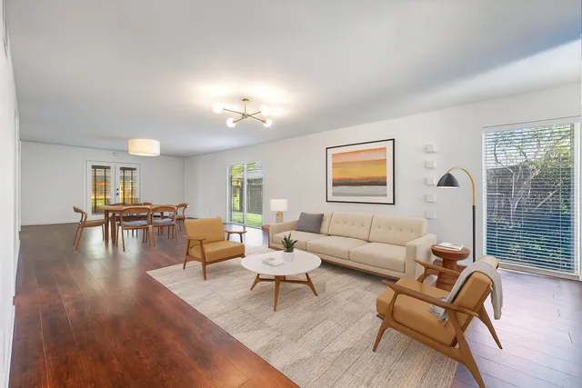 a living room with furniture or wooden floor and floor to ceiling windows