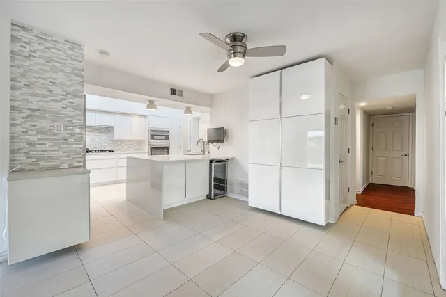 a kitchen with stainless steel appliances kitchen island granite countertop a refrigerator and a stove top oven