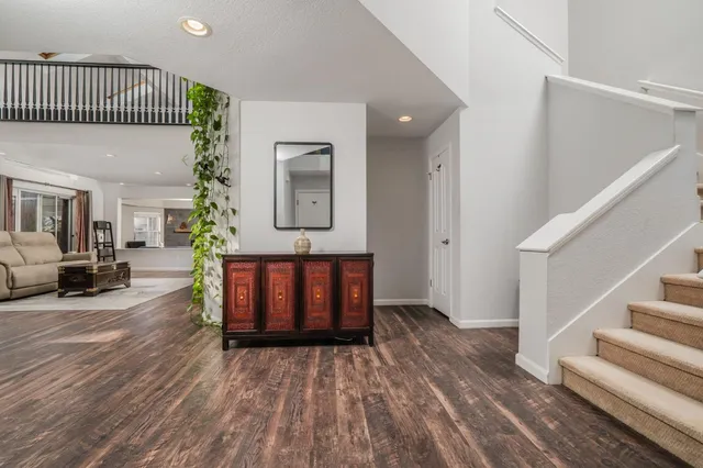 a living room with furniture and a wooden floor