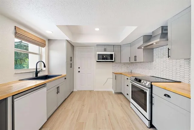 a kitchen with granite countertop a sink stove and cabinets