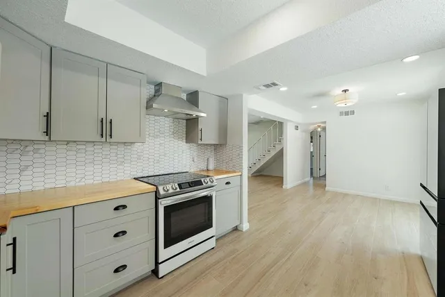 a kitchen with cabinets appliances and wooden floor