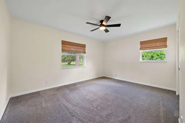 a view of a big room with window and ceiling fan