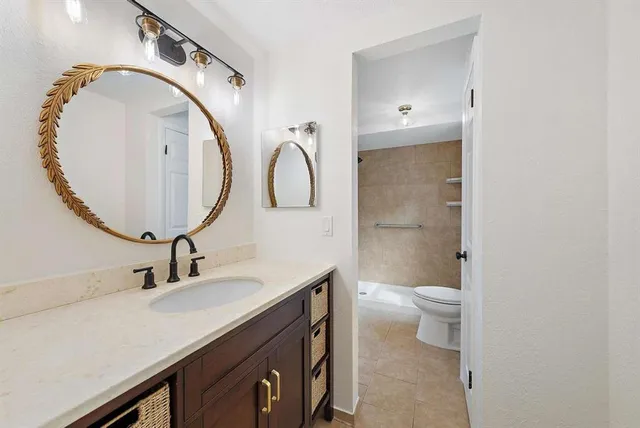 a bathroom with a sink a toilet and a mirror