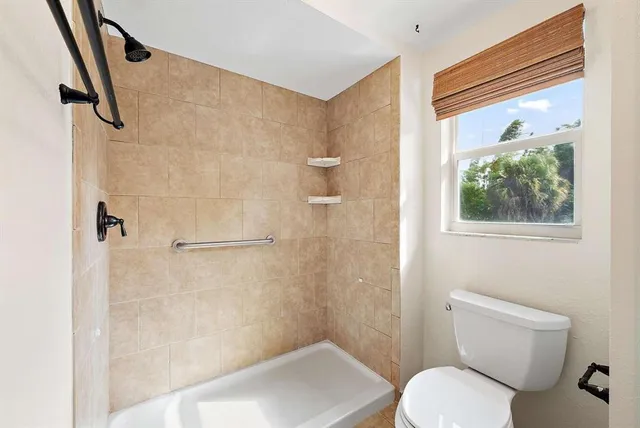 a bathroom with a toilet and a shower