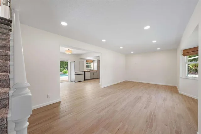 a view of empty room with wooden floor and fireplace