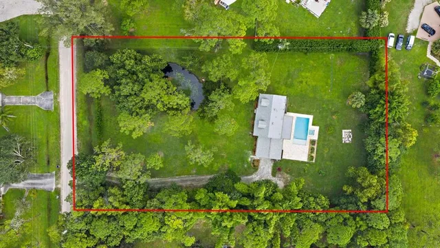 an aerial view of a house with a yard lake outdoor seating and yard