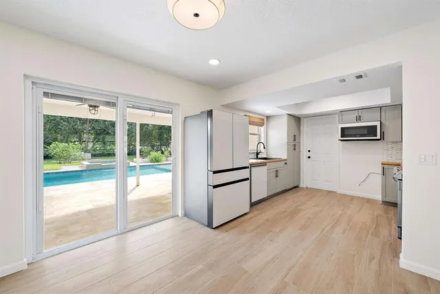 a kitchen with stainless steel appliances a refrigerator sink and microwave