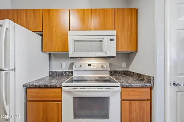 a kitchen with granite countertop wood cabinets and a stove top oven