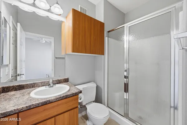 a bathroom with a granite countertop sink toilet and shower