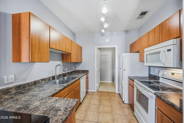 a kitchen with stainless steel appliances granite countertop a sink a stove and a refrigerator