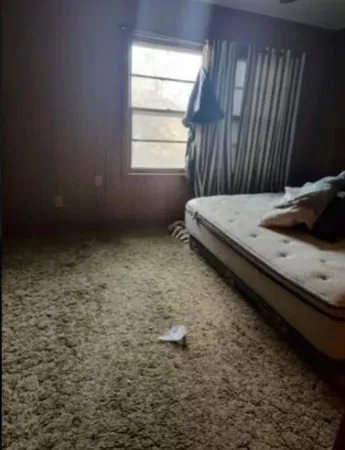 a bedroom with a bed and a window
