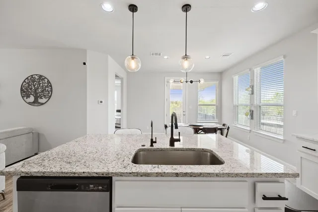 a kitchen with a granite countertop sink and a window