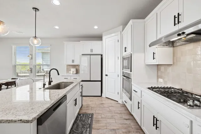 a kitchen with stainless steel appliances granite countertop a sink stove and refrigerator