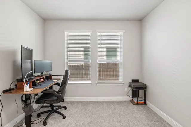a view of a workspace with furniture and a window