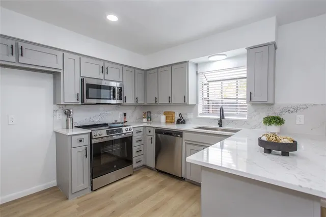 a kitchen with a sink white cabinets and appliances