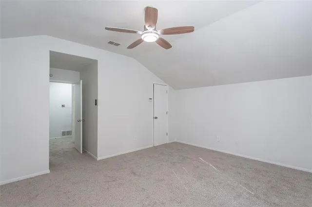 an empty room with a ceiling fan and a window