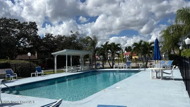 a view of a swimming pool with a table and chairs under an umbrella