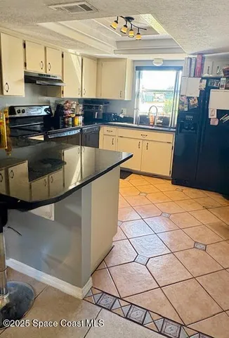 a kitchen with granite countertop a stove and a sink