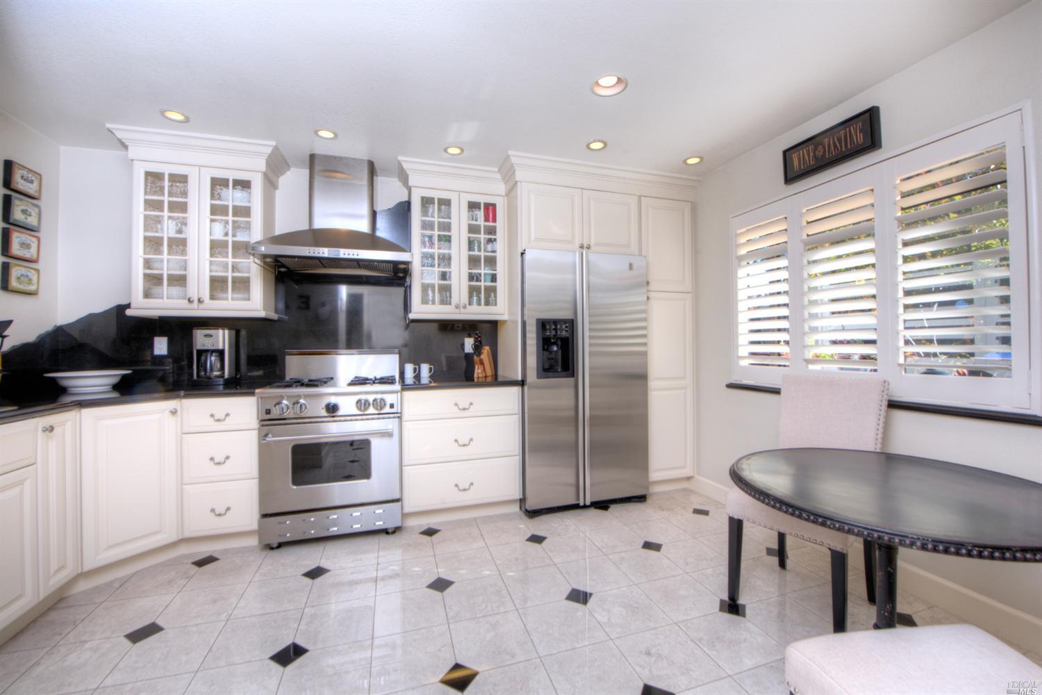 1120 Susan Way Novato, CA 94947 - Photo 1 of 1 a kitchen with stainless steel appliances kitchen island granite countertop a sink a stove a refrigerator cabinets and a dining table with wooden floor
