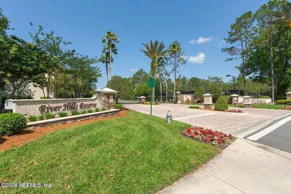 front view of house with a yard and palm trees