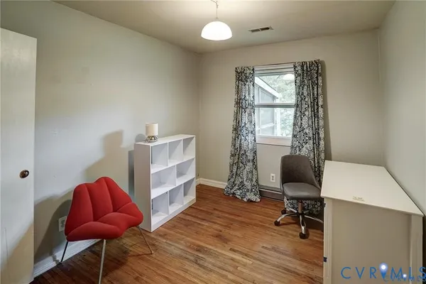 a view of a workspace with furniture and a window