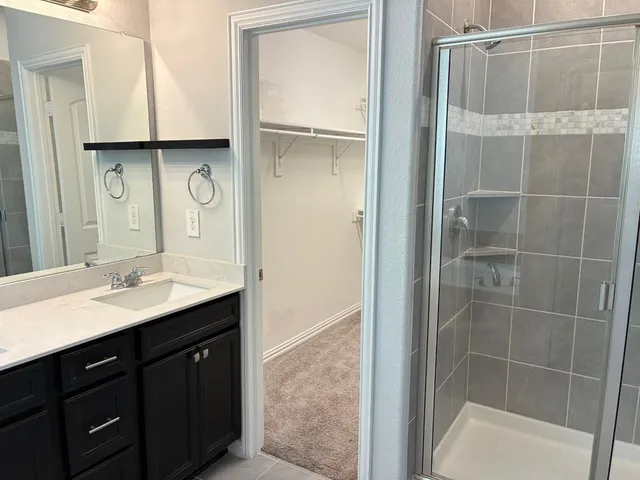a bathroom with a tub a sink and mirror
