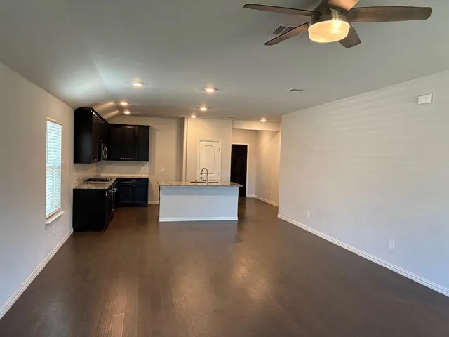 an empty room with windows and fireplace