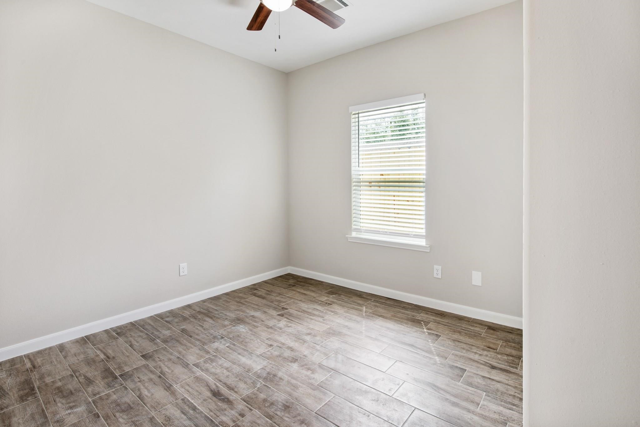 5911 Westover Street, Unit B Houston, TX 77033 - Photo 14 of 21 an empty room with wooden floor and windows