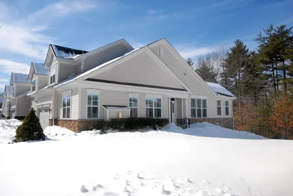 a view of a house with a yard covered in snow