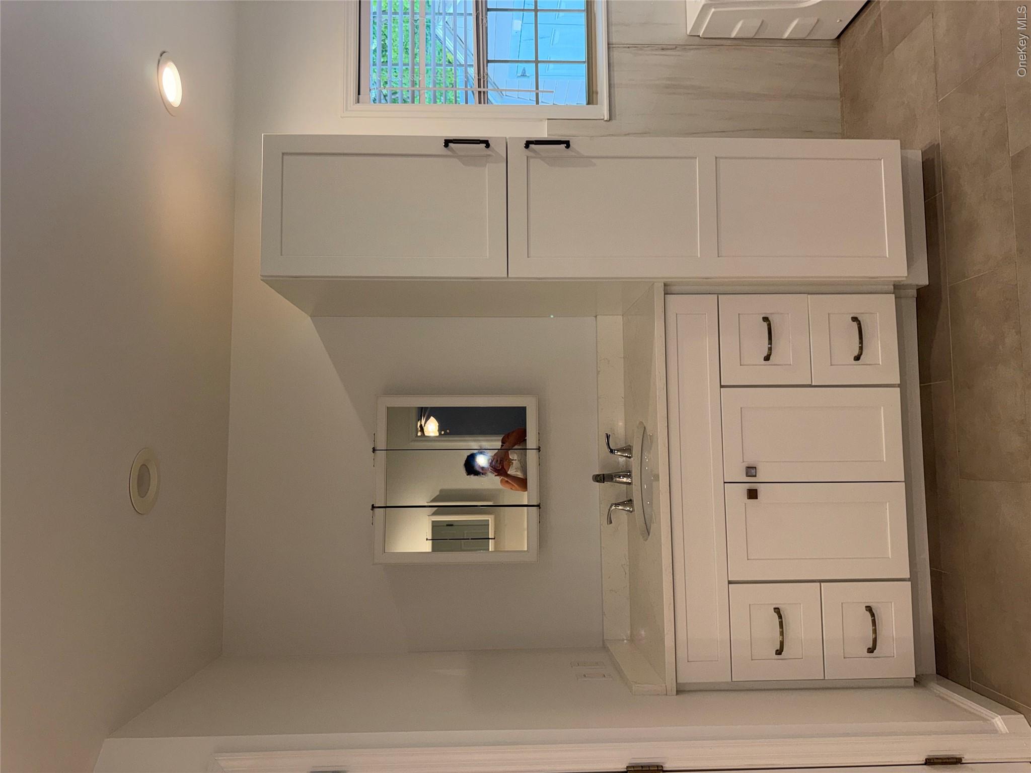 1661 Old Country Road, Unit 516 Riverhead, NY 11901 - Photo 40 of 50 a bathroom with a double vanity sink and mirror