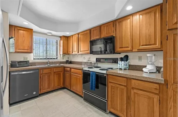 a kitchen with stainless steel appliances granite countertop a stove sink microwave and window